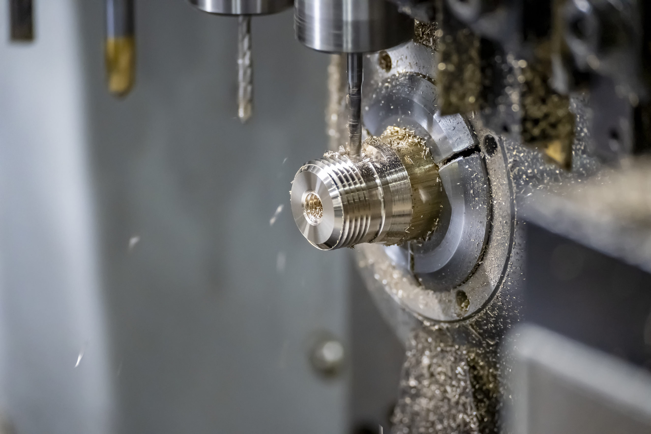 The multi-tasking CNC lathe machine swiss type tapping at the brass shaft . The hi-technology metal working process with turning machine control by CNC program